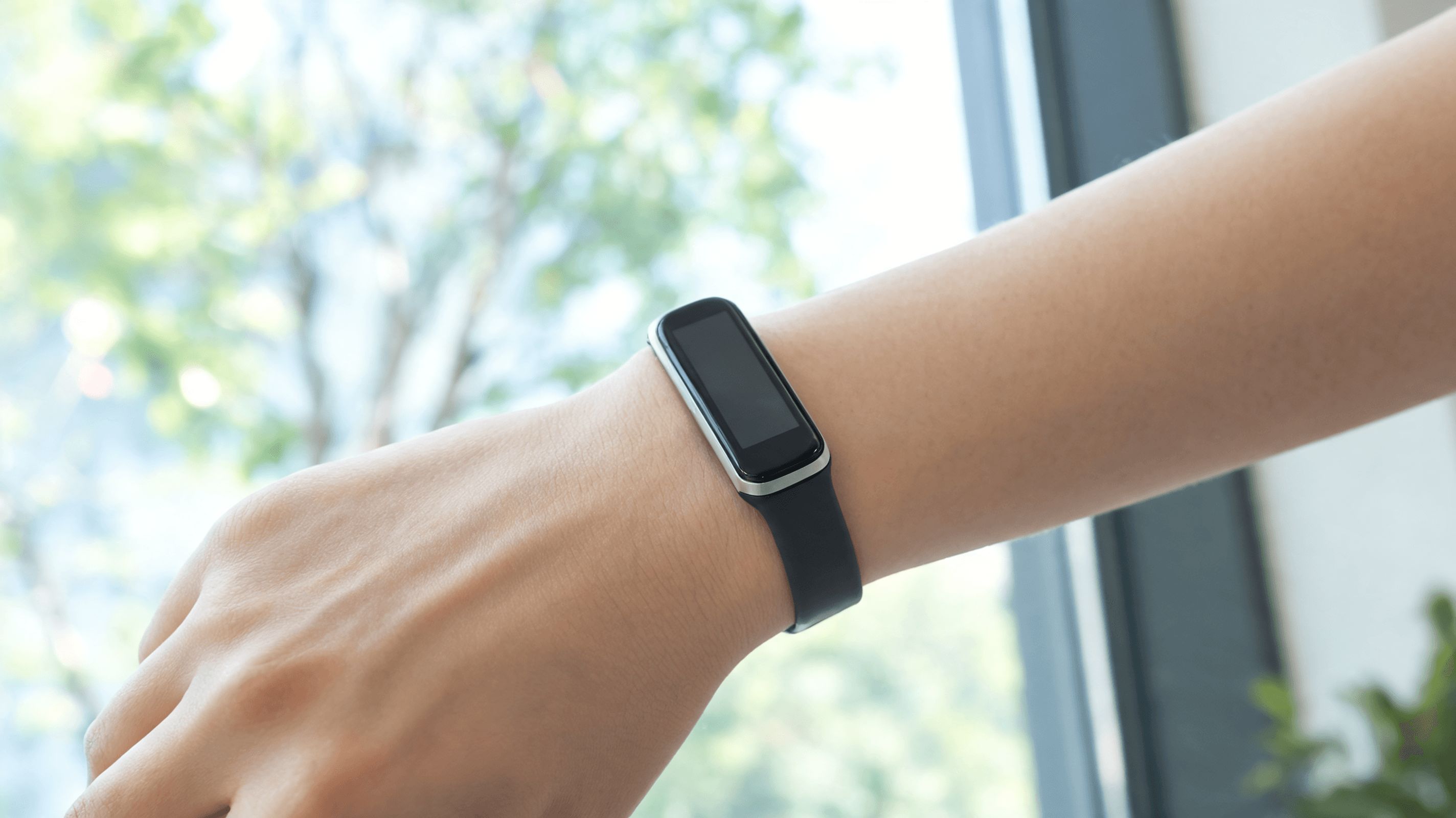 A minimalist, sleek fitness tracker on a wrist in a natural lighting environment, professional produ